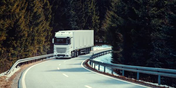 Klaviertransport Rotenburg: Lkw fährt auf einer kurvigen Straße durch den Wald