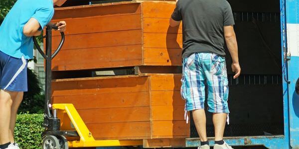 Möbellift Rotenburg: Zwei Helfer tragen einen Holzschrank aus einem Lkw
